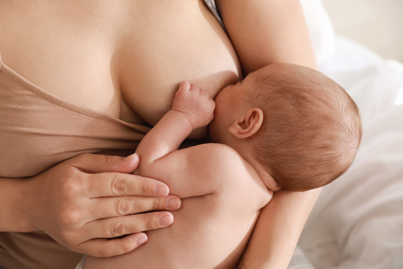 Mother Breastfeeding Her Newborn Baby at Home, Closeup